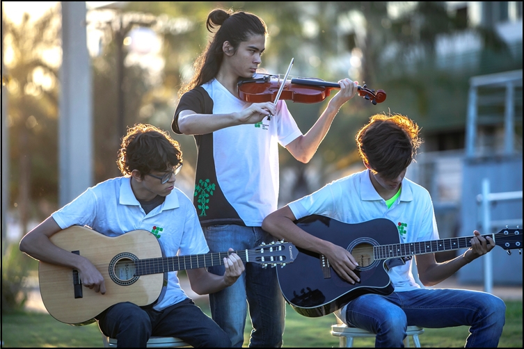 Ex-alunos treinando violão e violino em um fim de tarde no Câmpus