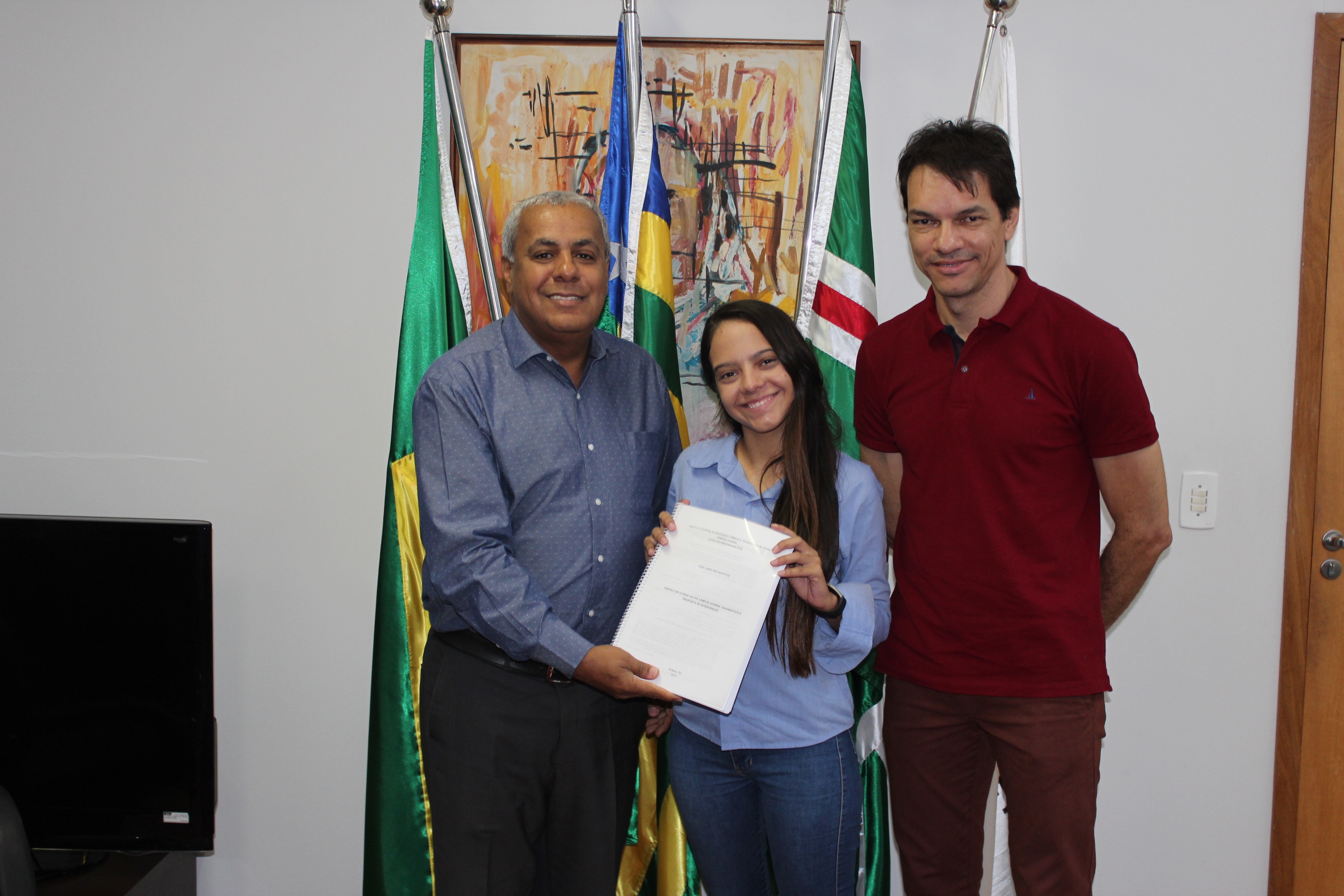 A aluna Taís Santos e o orientador, Paulo Francinete, realizaram a entrega do trabalho ao reitor, Jerônimo Rodrigues